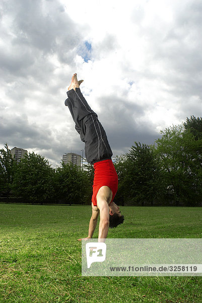Mann beim Handstand im Park