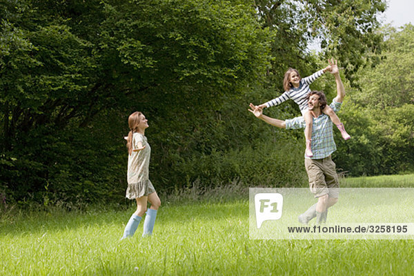 Family running in country field
