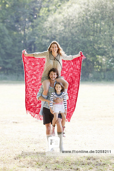 Family with red blanket in country field