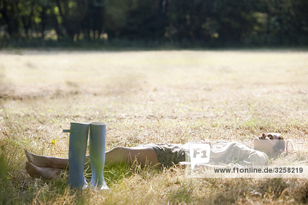 Woman lying in countryside field
