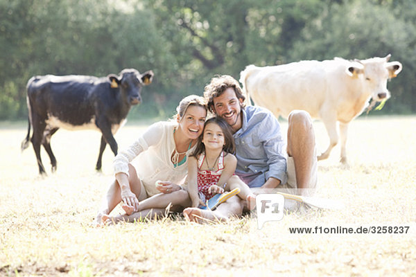 Family sitting together in country field