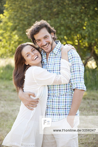 Portrait of couple embracing in country