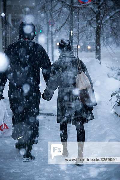 Couple walking in heavy snowing in Oslo  Norway.
