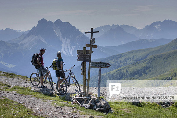 Italien  Dolomiten  Mountainbiker neben den Schildern