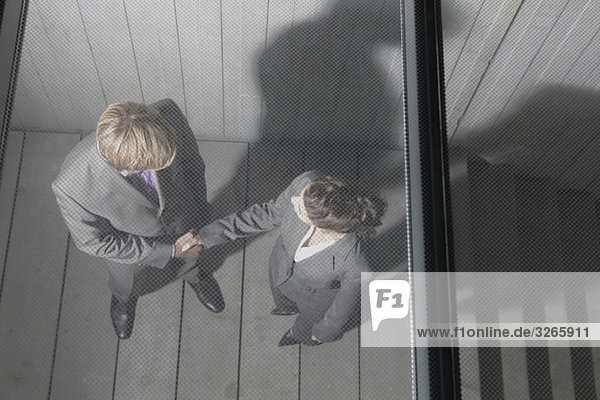 Deutschland,  Köln,  Geschäftsleute beim Händeschütteln auf der Treppe,  erhöhte Ansicht