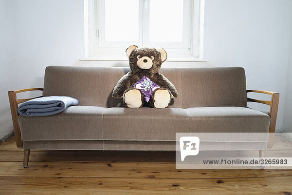 Teddy on sofa with gift parcel