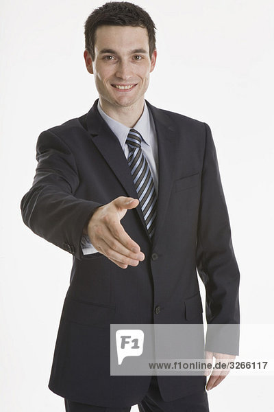 Geschäftsmann  der seine Hand ausstreckt  lächelnd  Porträt