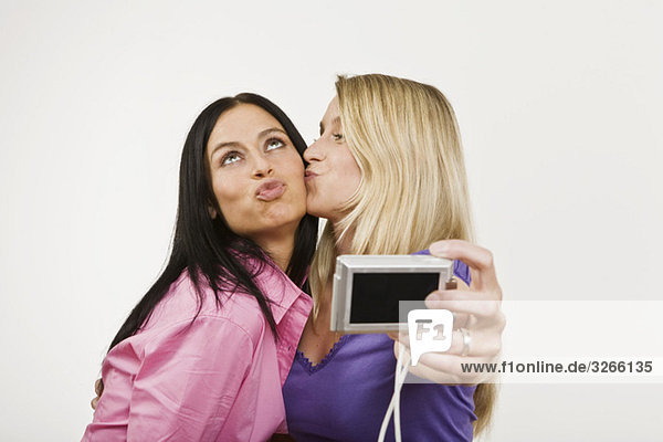 Two women using digital camera  portrait mouth