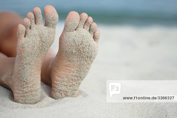 Italy  Sardinia  Person lying on beach  sandy feet