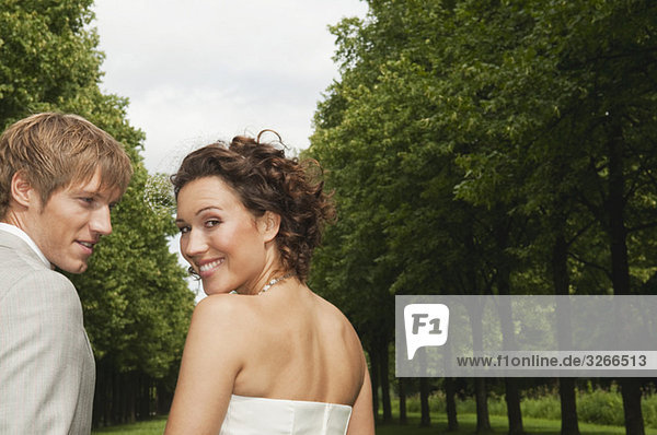 Deutschland  Bayern  Hochzeitspaar im Park  lächelnd  Portrait  Nahaufnahme