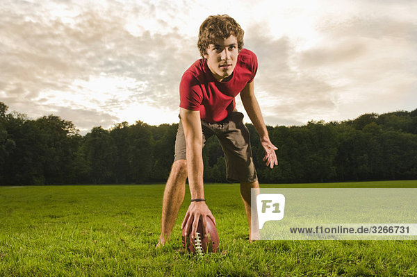 Starnberger See  Young man on lawn holding rugby ball  portrait