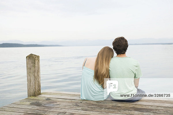 Deutschland  Bayern  Starnberger See  Junges Paar am Steg  Rückansicht