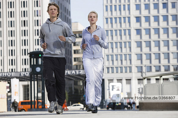 Germany  Berlin  Young couple jogging together
