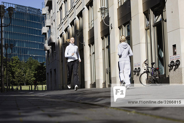 Zwei Frauen  die in der Stadt joggen.