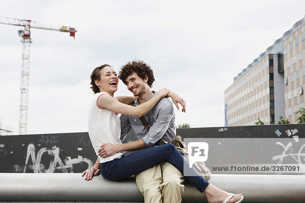 Germany  Berlin  Young couple in front of new building  cranes in background