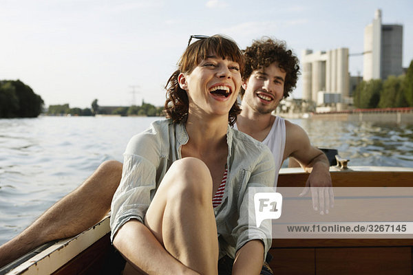 Germany  Berlin  Young couple on motor boat  laughing  portrait