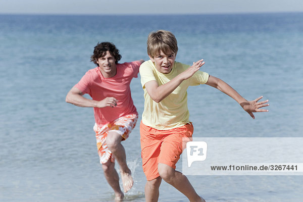 Spanien  Mallorca  Vater und Sohn (8-9) beim Laufen über den Strand