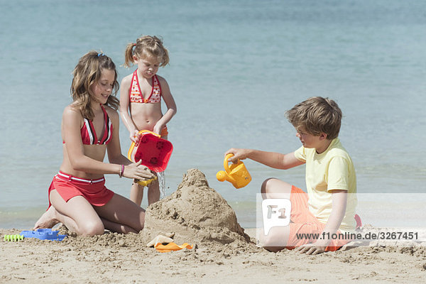 Spanien  Mallorca  Kinder bauen Sandburg am Strand