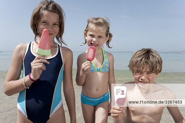 Spanien  Mallorca  Kinder mit Eis am Strand  lächelnd  Portrait
