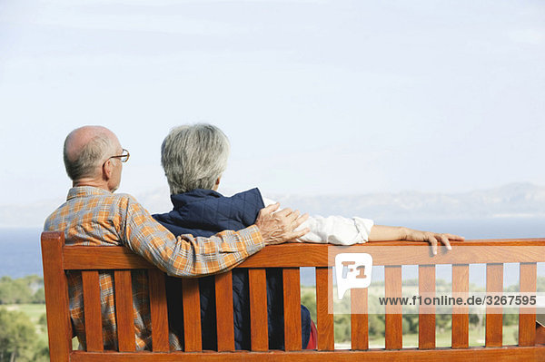 Spain  Mallorca  Senior couple sitting on bench  rear view