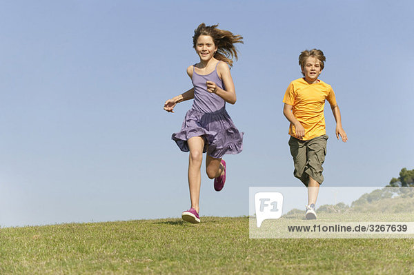 Boy (8-9) and girl (10-11) running together