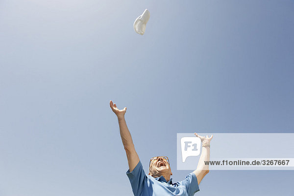 Senior man throwing shoe in the air  cheering  portrait