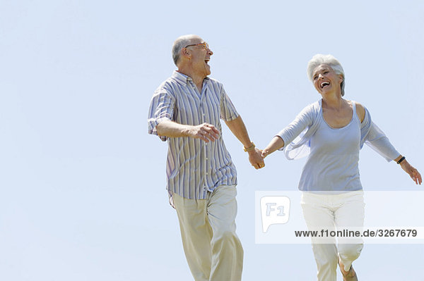 Senior couple running hand in hand  portrait
