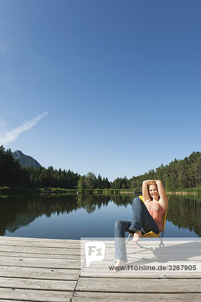 Italien  Südtirol  Frau beim Sonnenbaden am Steg am See