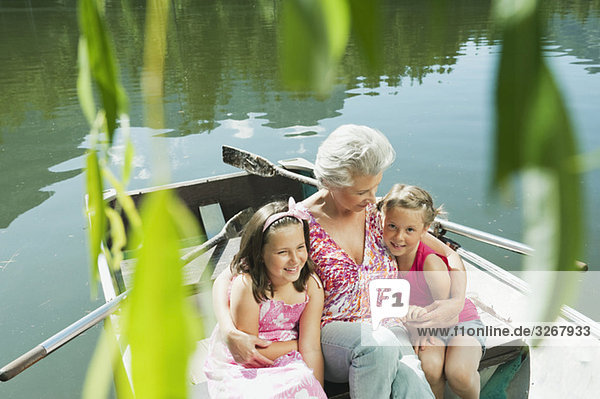 Italy  South Tyrol  Grandmother and grandchildren (6-7) (8-9) sitting in rowing boat  portrait