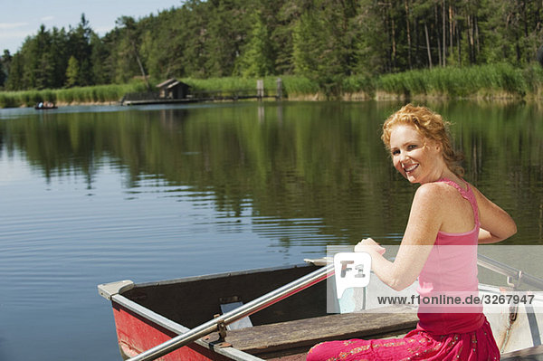 Italy  South Tyrol  Woman rowing boat  smiling  portrait
