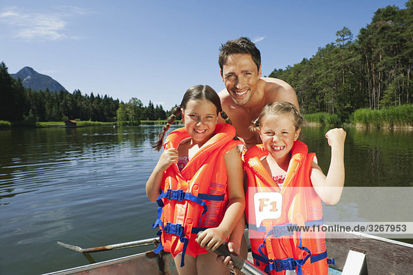 Italy  South Tyrol  Father and children (6-7) (8-9)  wearing life jackets  smiling  portrait