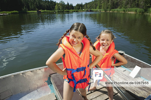 Italy  South Tyrol  Two girls (6-7) (8-9) wearing life jackets  smiling  portrait