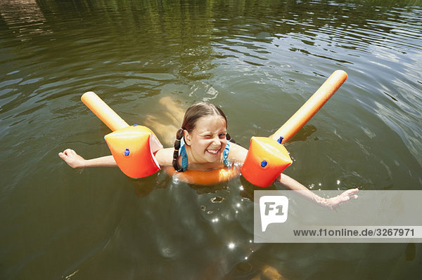Italy  South Tyrol  Girl (8-9) swimming in lake  smiling  portrait
