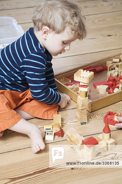 Boy (2-3) playing with building blocks