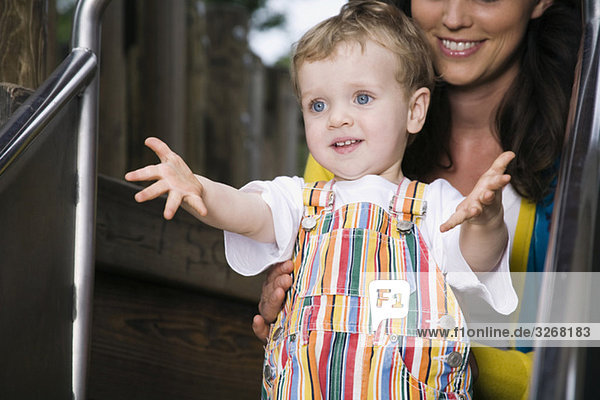 Deutschland  Berlin  Mutter hält Sohn (18-23 Monate) auf Folie  lächelnd