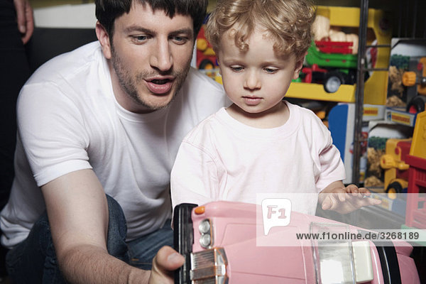 Deutschland  Berlin  Vater mit Sohn (2-3) hält Spielzeugauto im Geschäft