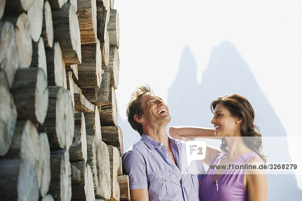 Italien  Südtirol  Seiseralm  Paar steht neben Holzhaufen  Portrait
