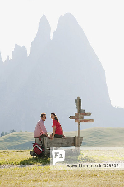 Italien  Südtirol  Seiseralm  Paar auf Bank sitzend