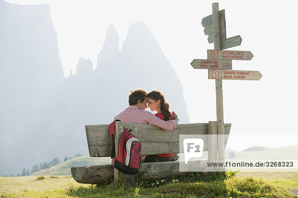 Italien  Südtirol  Seiseralm  Paar auf Bank sitzend  Kopf an Kopf