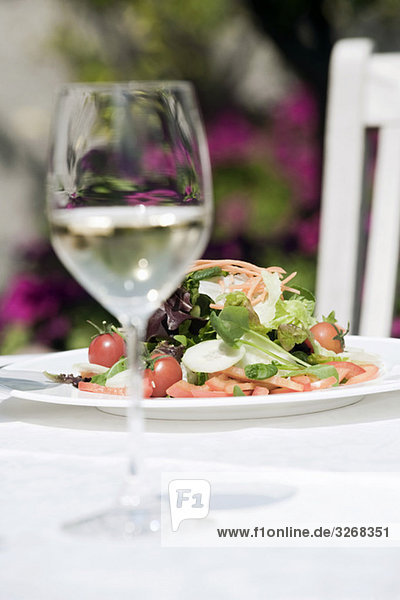 Italien  Südtirol  Gemischter Salat auf Teller mit einem Glas Weißwein
