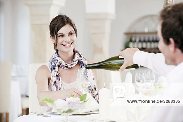 Couple in restaurant  man pouring wine into glass