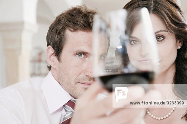 Couple in restaurant  man holding glass of red wine  portrait