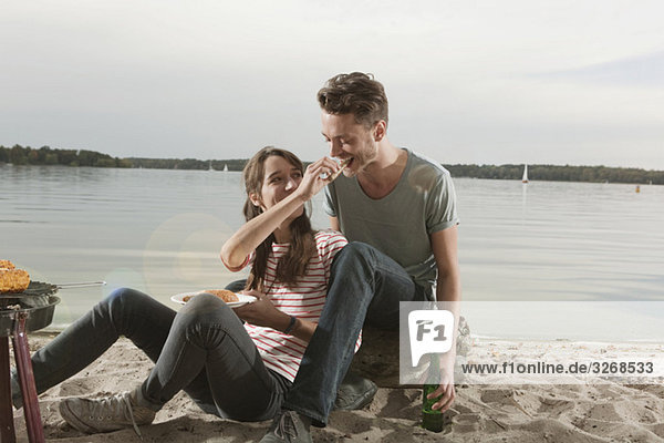 Germany  Berlin  Lake Wannsee  Young couple having a barbecue