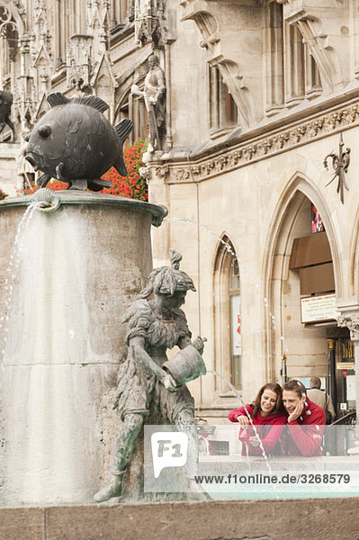 Germany  Bavaria  Munich  Couple standing by fountain