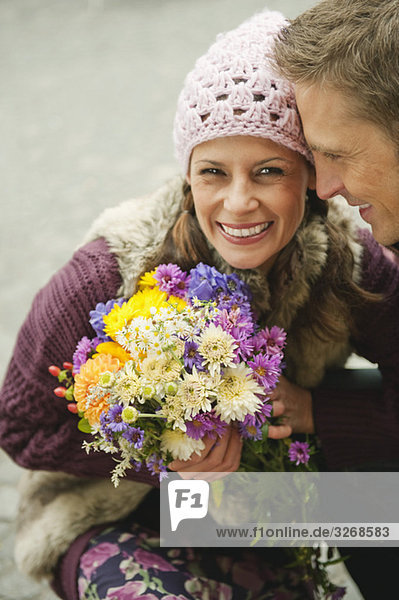 Paar  Frau hält Blumenstrauß  lächelnd  Portrait