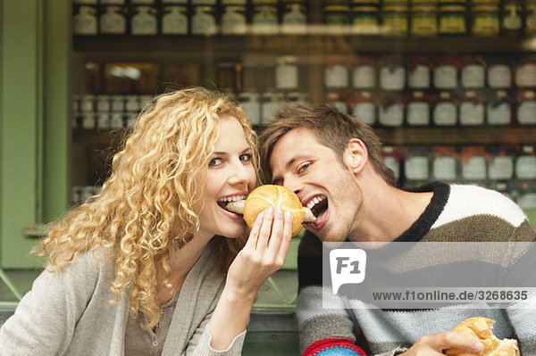 Deutschland  Bayern  München  Junges Paar am Viktualienmarkt beim Snack  Portrait