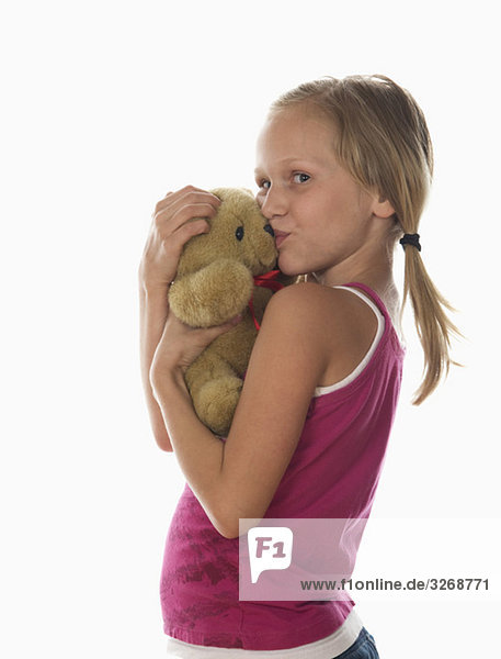 Porträt des Mädchens (10-11) kuschelnder Teddybär  Studioaufnahme