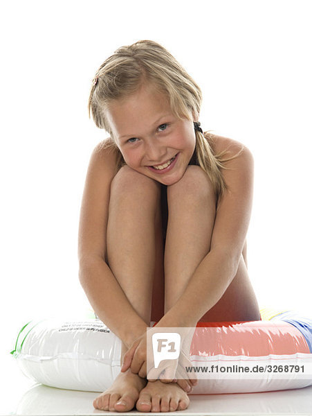 Mädchen (10-11) sitzend auf schwimmendem Reifen  Portrait