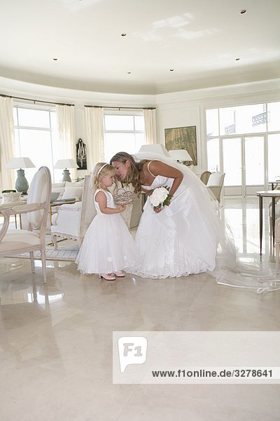 Bride whispers to young flower girl