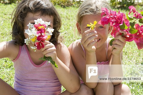 Zwei junge Mädchen mit einigen Blumen